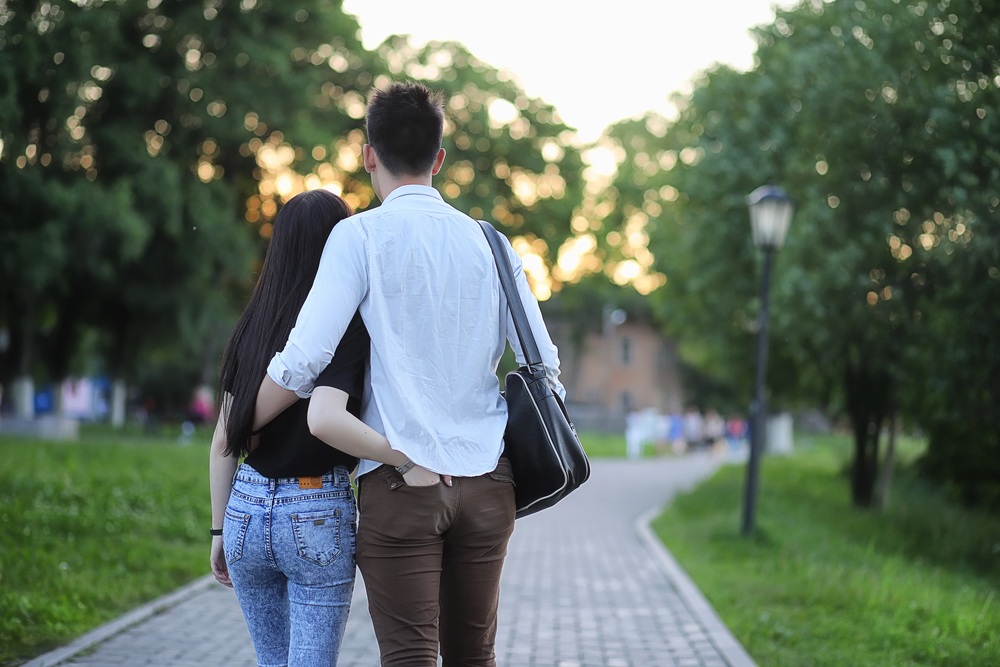 Back view of a couple  in a reflective mood while holding each others waist
