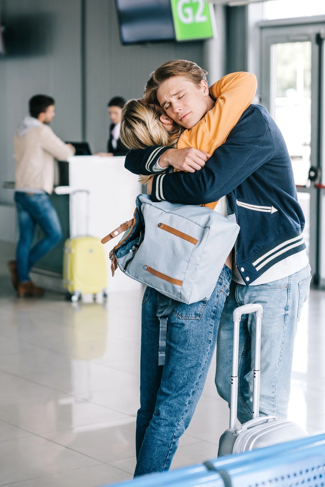 Couple hugging goodbye at the airport