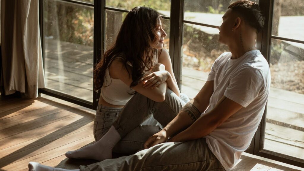 man and woman sitting on the floor starring at each other 