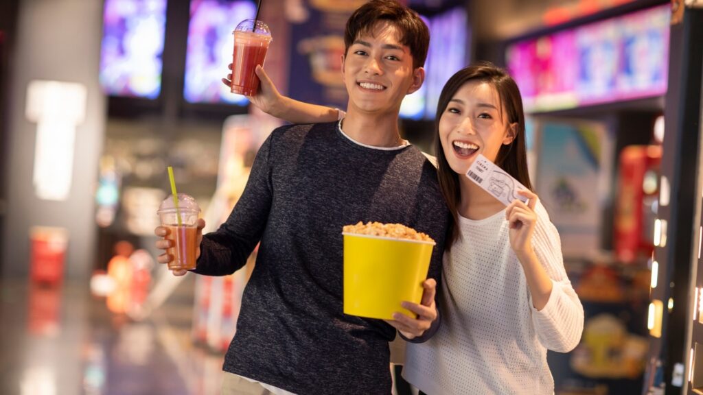Couple having a great time in the cinema with popcorn