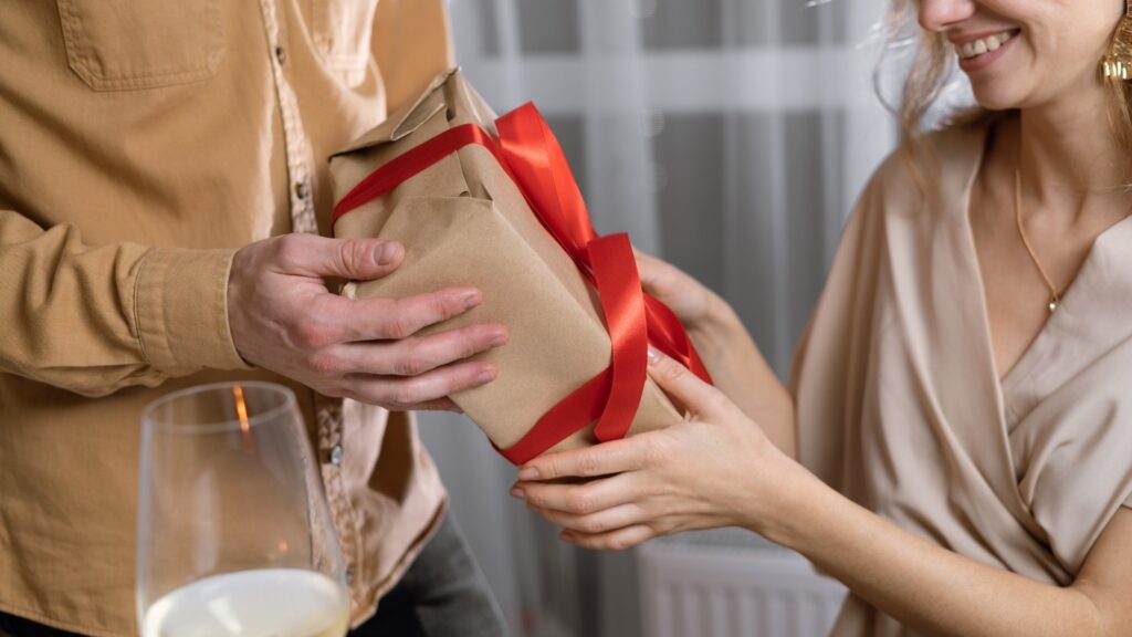 man giftfing lady a wrapped personalised calendar