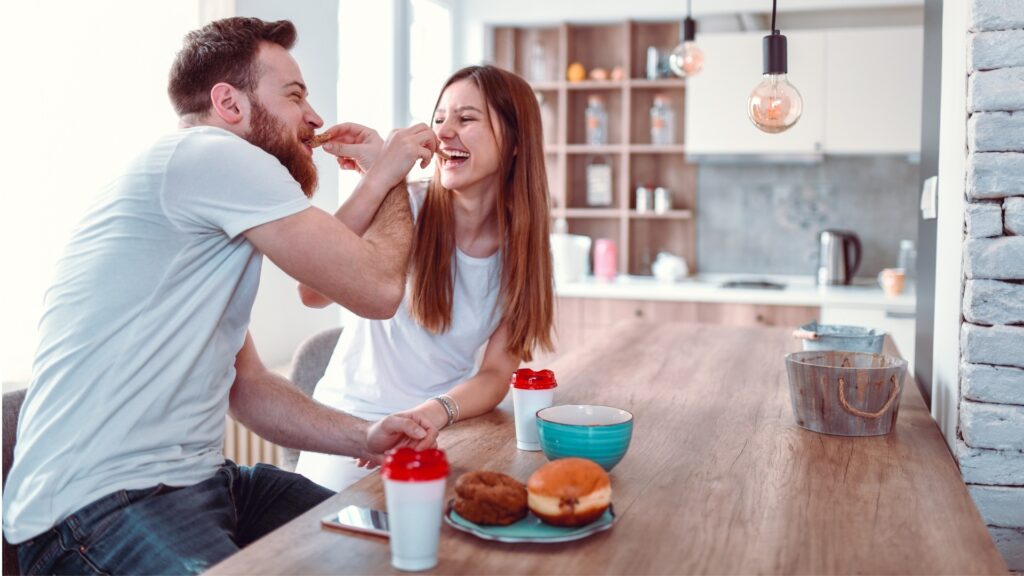 couple joyfully feeding each other