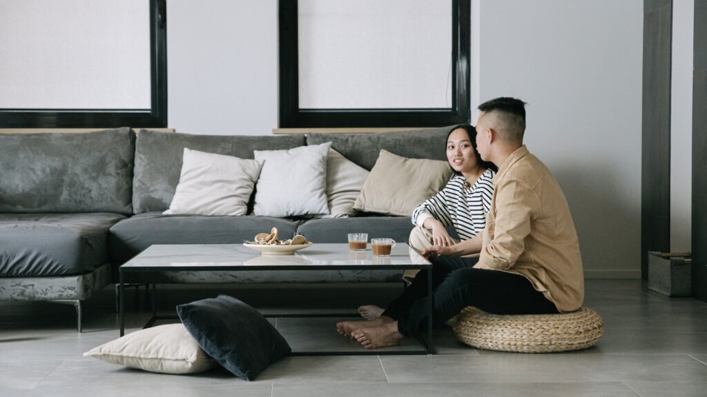 man sitting with his long-distance partner reassuring her while starring at her