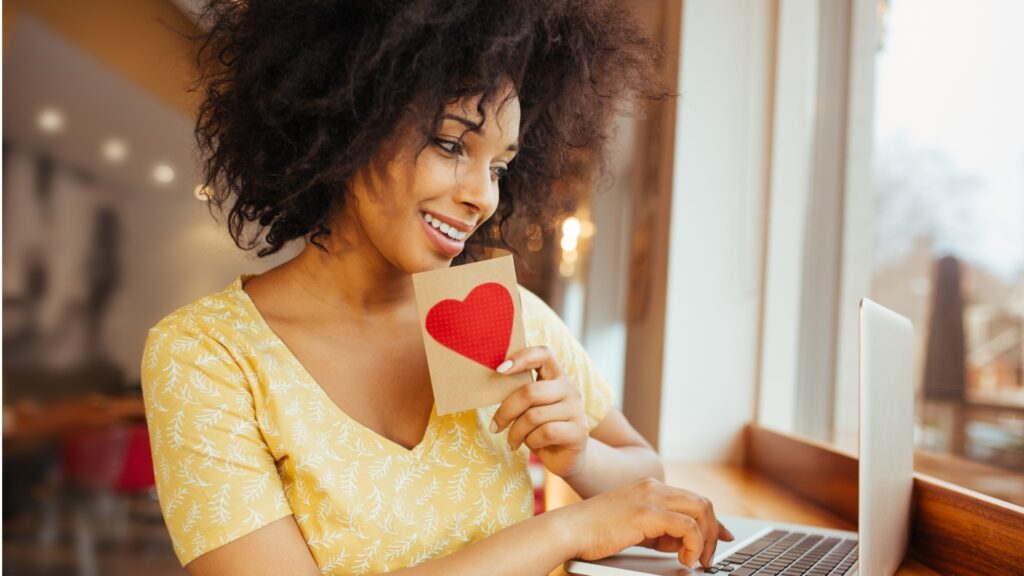 lady-holding-up-a-love-card-during-video-call-with-boy-friend