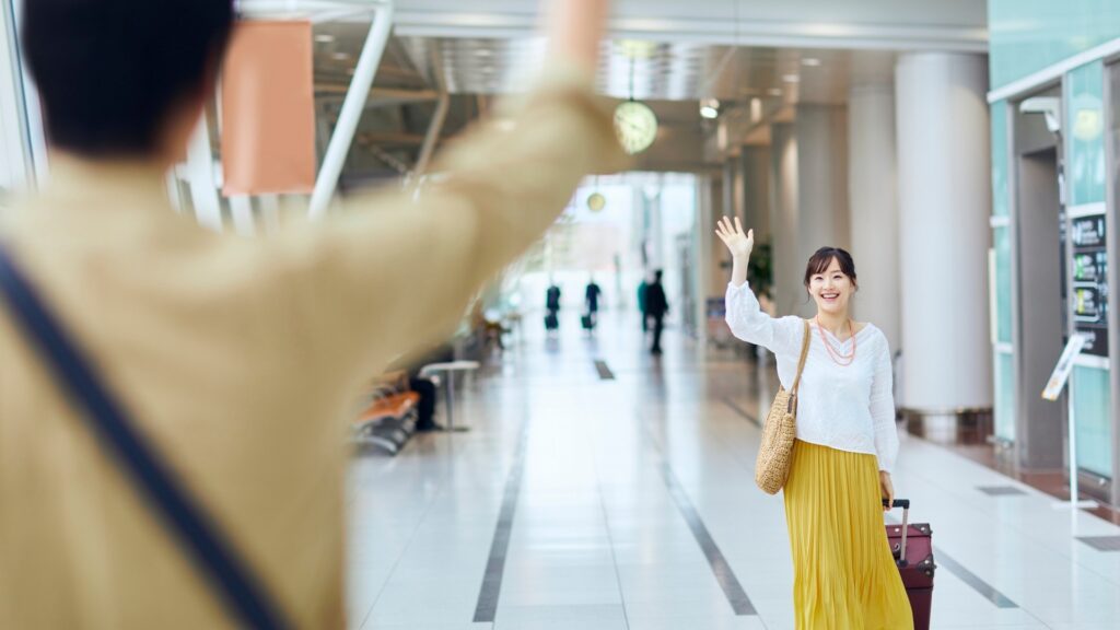long distance couple waving at each other at the airport