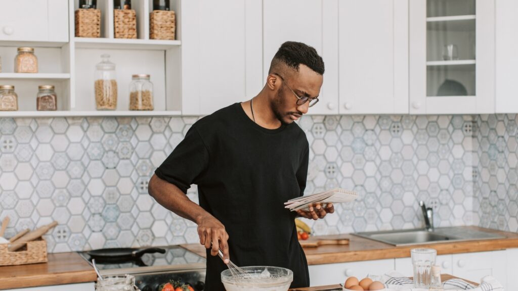 man trying to taste the meal he is making