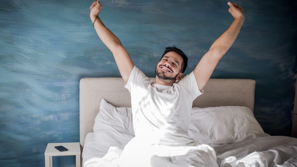 man bored and about to go to bed only to remeber he can play a game to lighten his mood