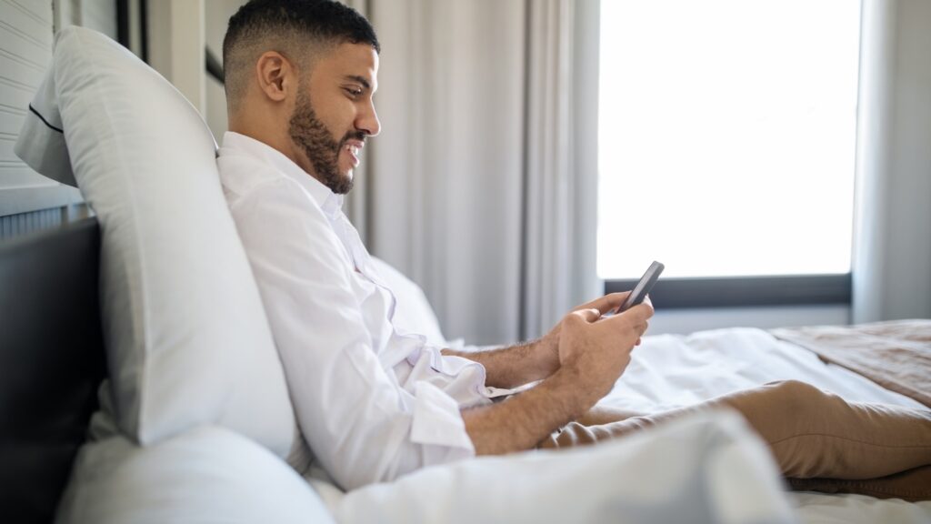 man asking his long distance partner some questions during virtual dinner