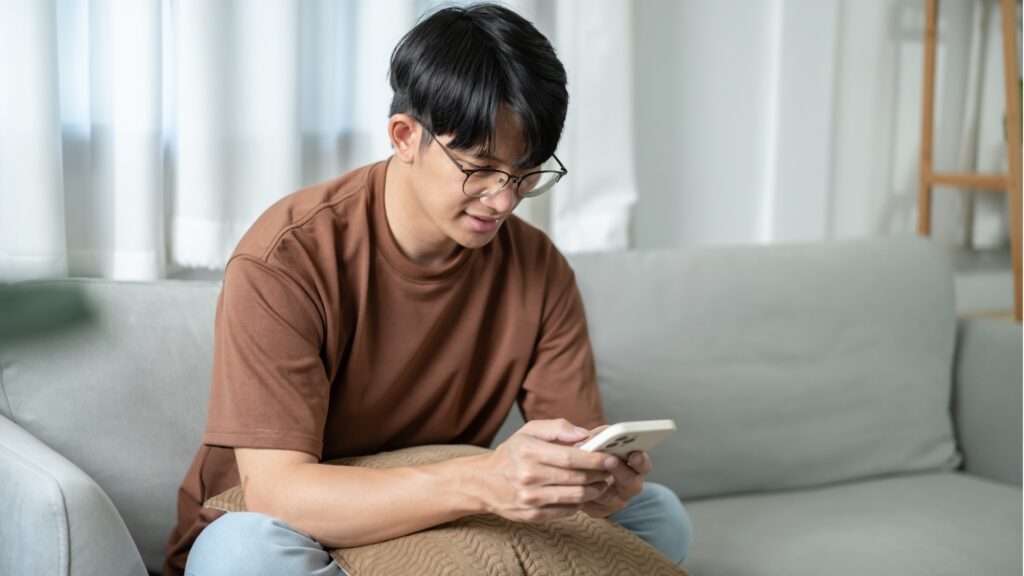 man happily going through his daily tasks as a freelancer not that bothered about his text message that hasn't been responded to by his girlfriend because he knows she is genuinely caught up with work