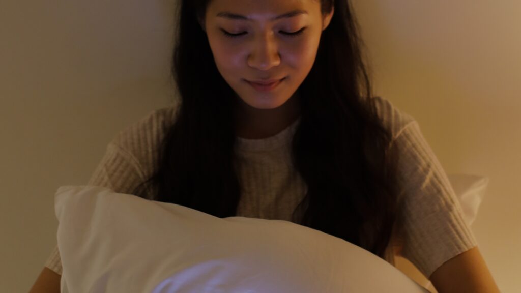 A lady sitting on her bed, sulking
