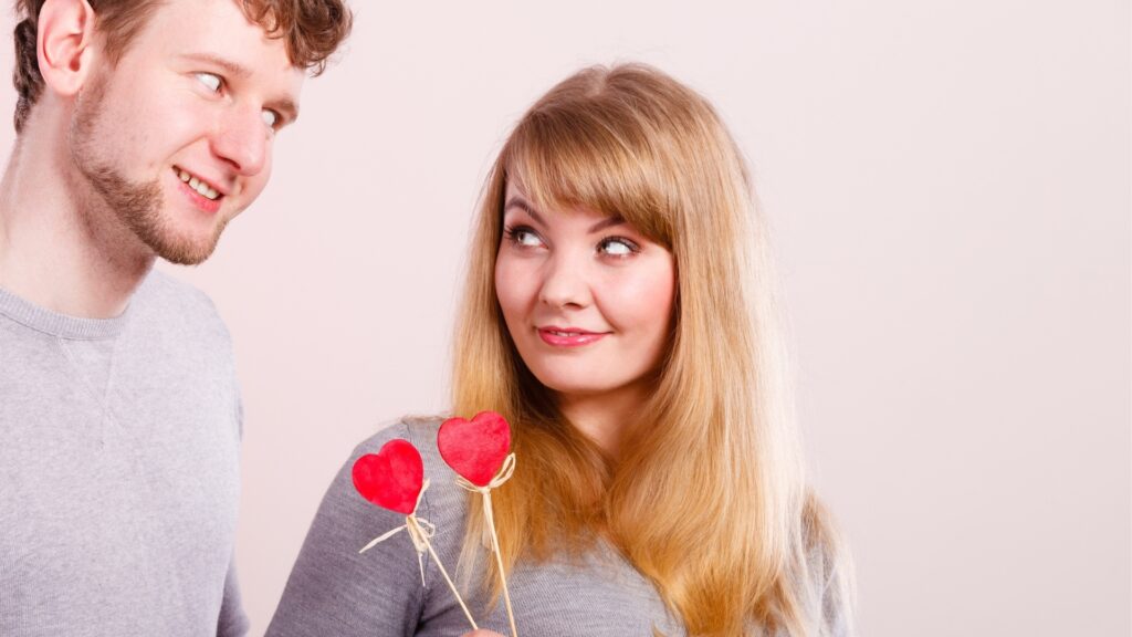 lady giving her man flowers and asking him to deduce what it is for