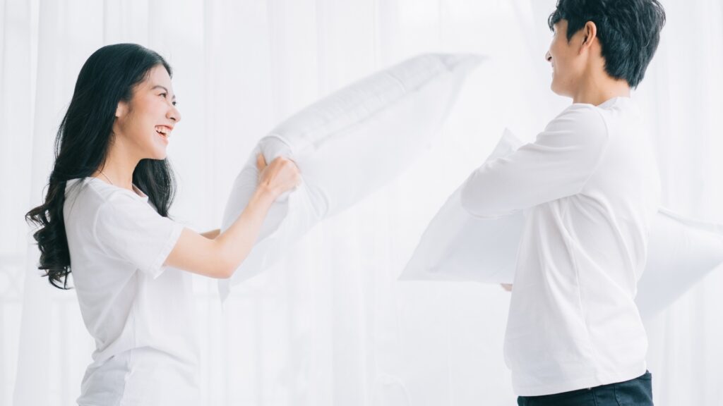 lady throwing a white pillow on her man as he failed the game