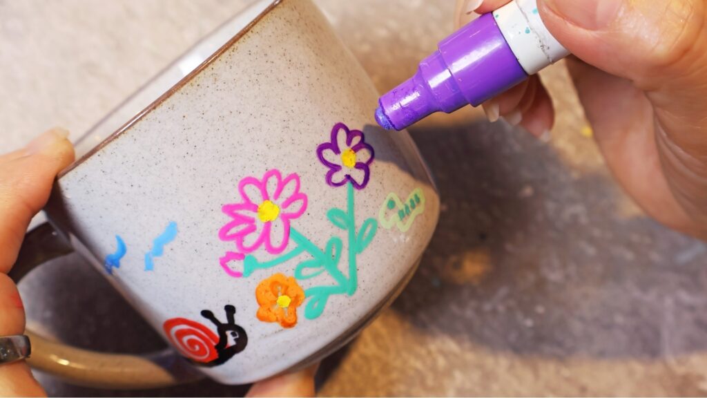 female hand painting a mug