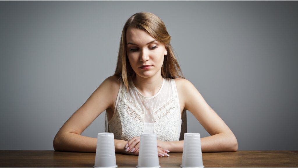lady guessing what the objects inside the cup might be