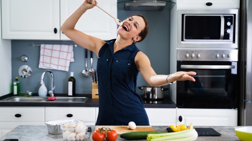 lady vibing to her favorite music as she cooks over video with her long distance partner