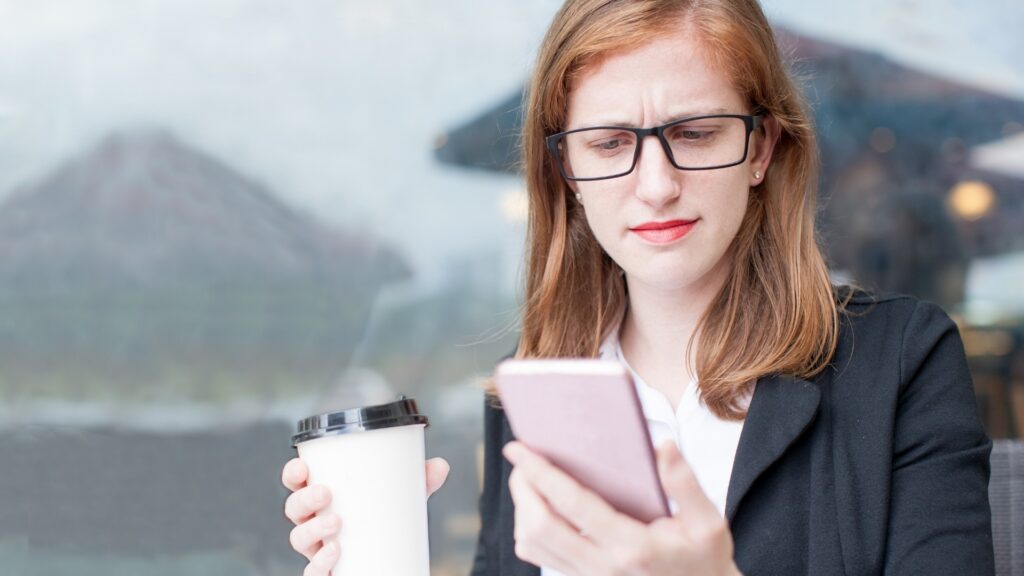 lady holding a coffee while reading through a message from her long-distance partner