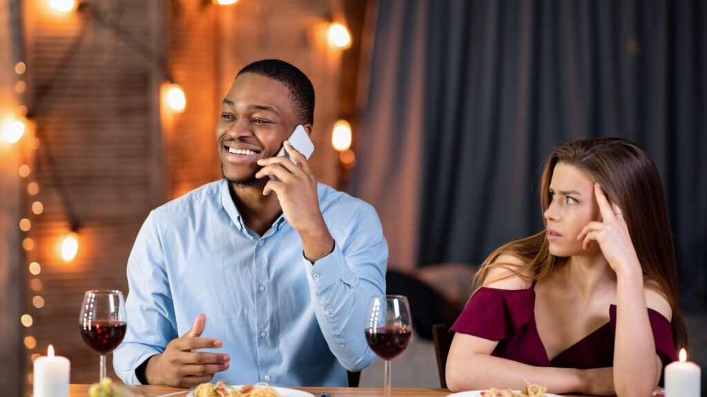 man rushing to take a phone call during a dinner date