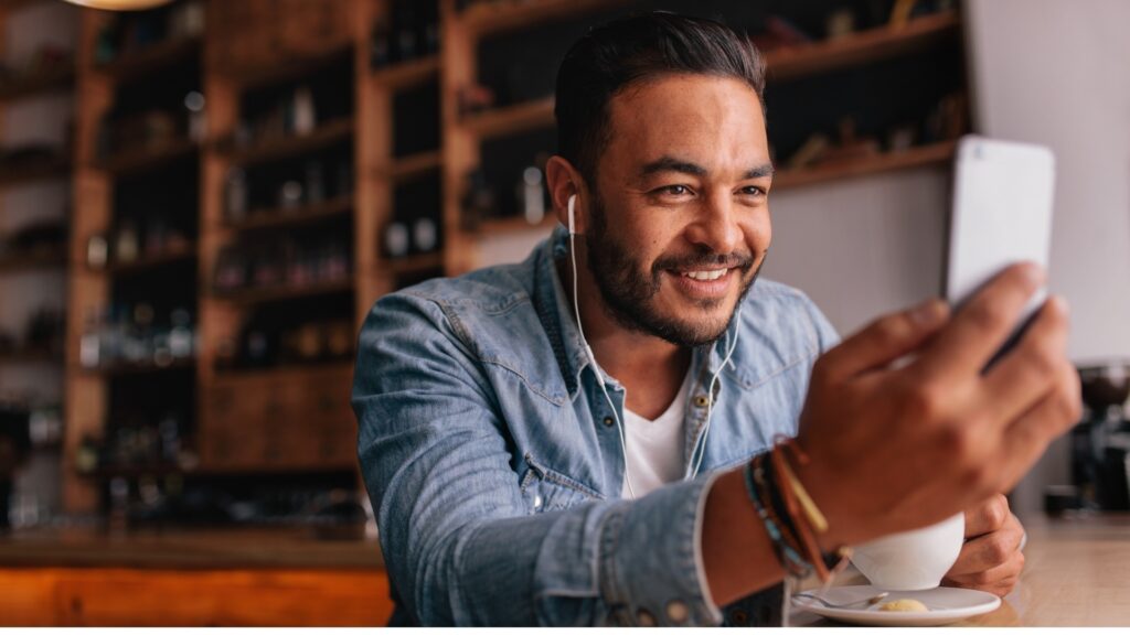 man in a coffee shop while having a video call with his long-distance partner 