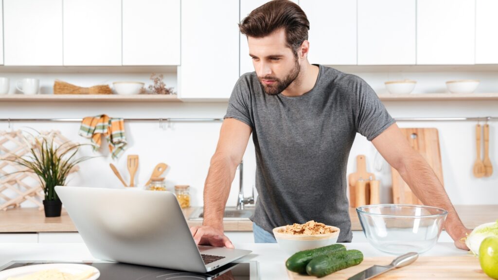 man trying to cook a home made meal from scratch with the girlfriend over video