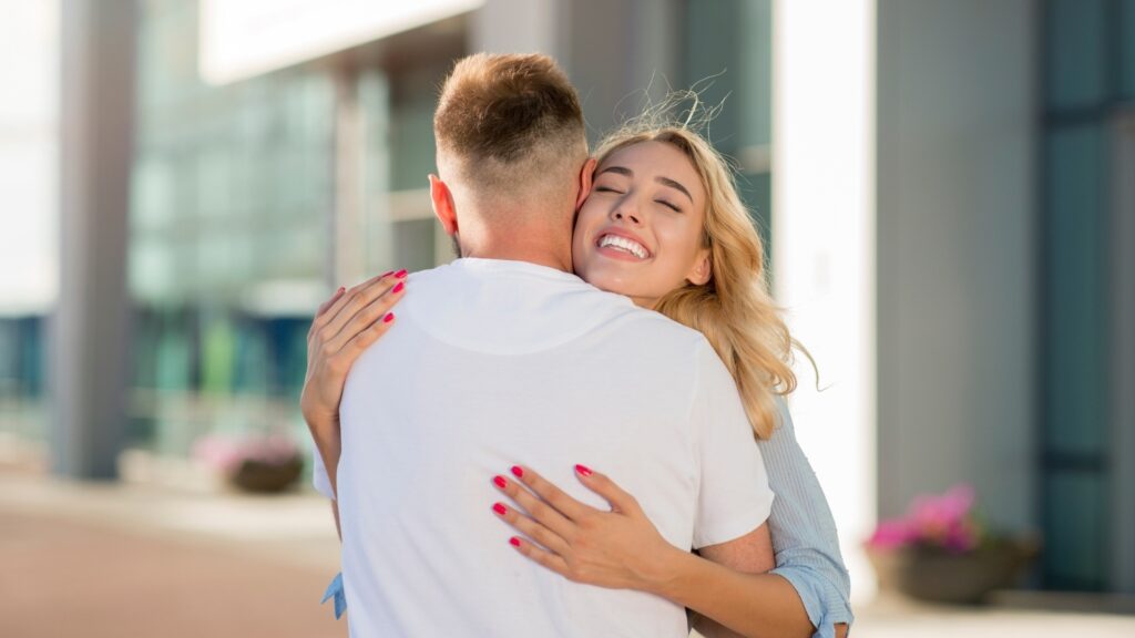 long distance couple hugging themselves good bye at the airpot
