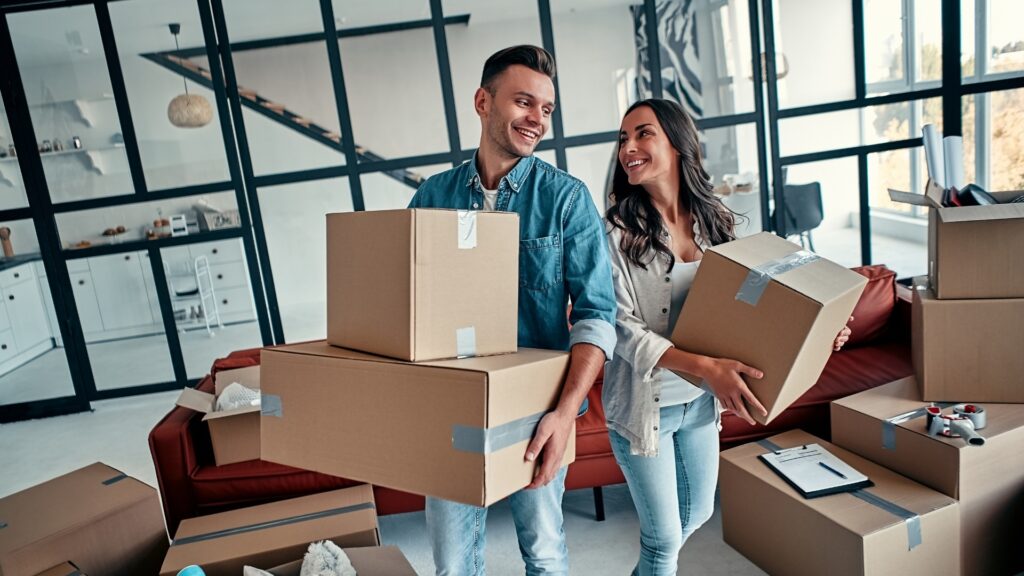 long distance couple carrying their properties into their home