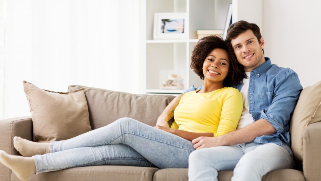 international couple sitting together on a sofa during visit