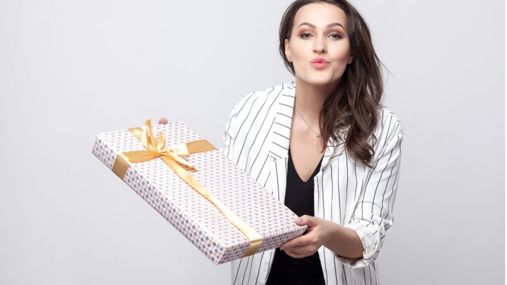 lady pouting her lips as she holds out her care package