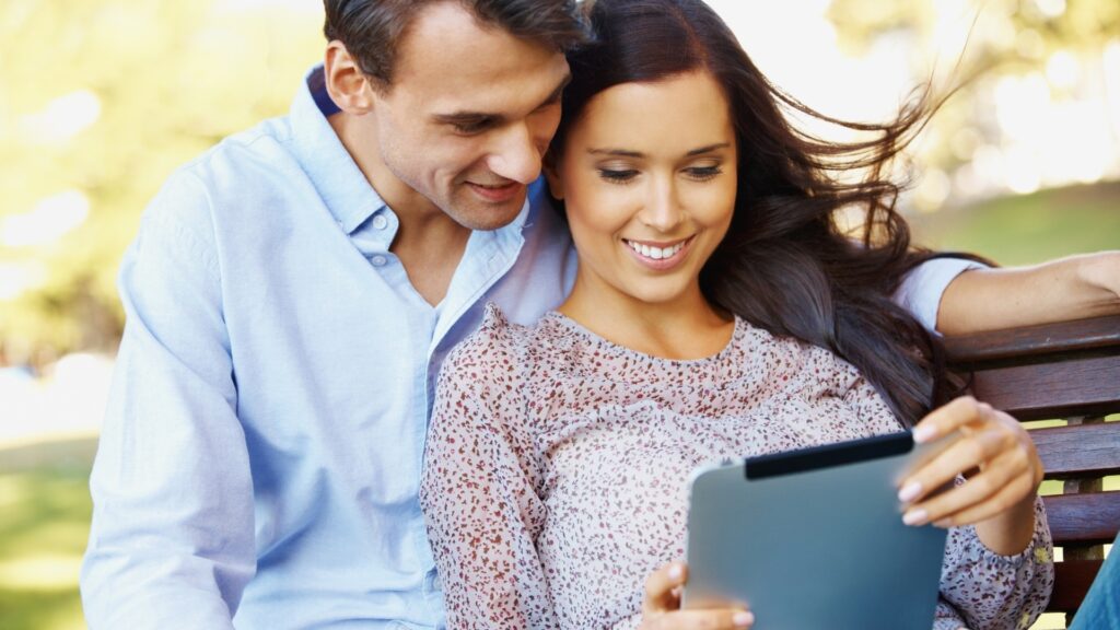 couple looking at an album on their tablet