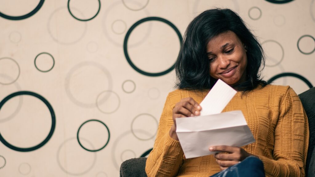 black young lady opening a new letter