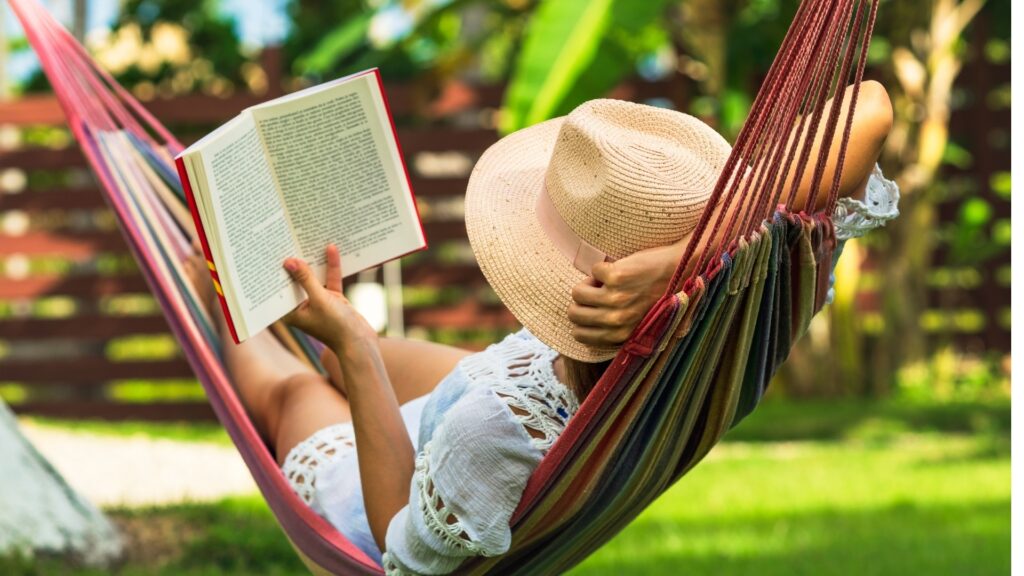lady relaxing outside her house with a book
