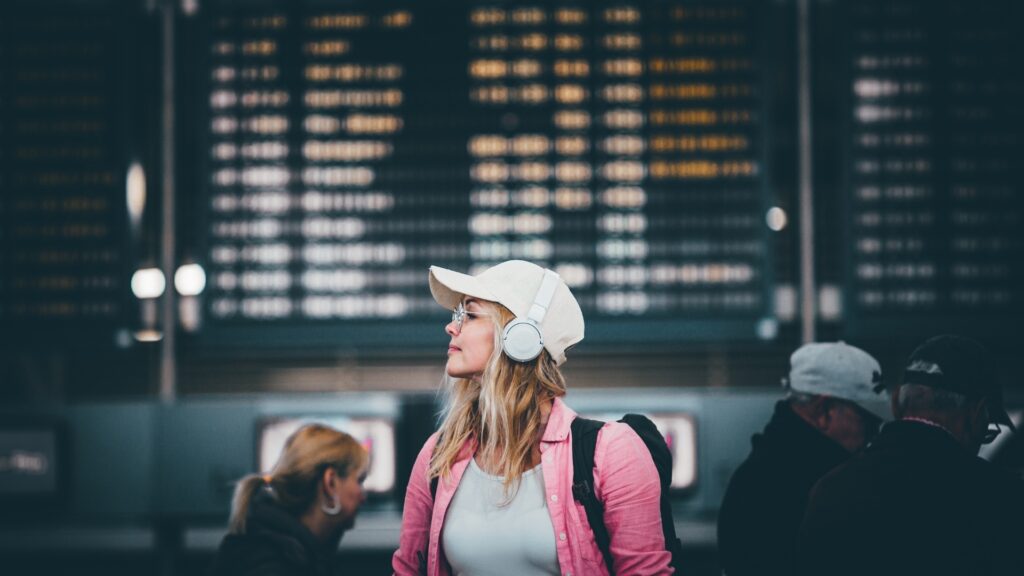 lady at the airport waiting for her long distance partner to pick her
