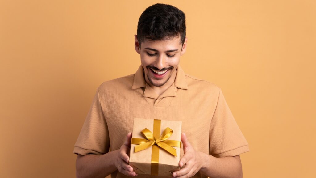 man on a yellow background excited about his personalized gift box