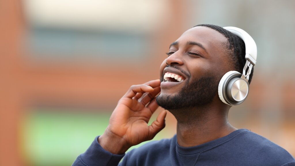 man jamming his favorite playlist curated for him by his long distance partner with his headphone