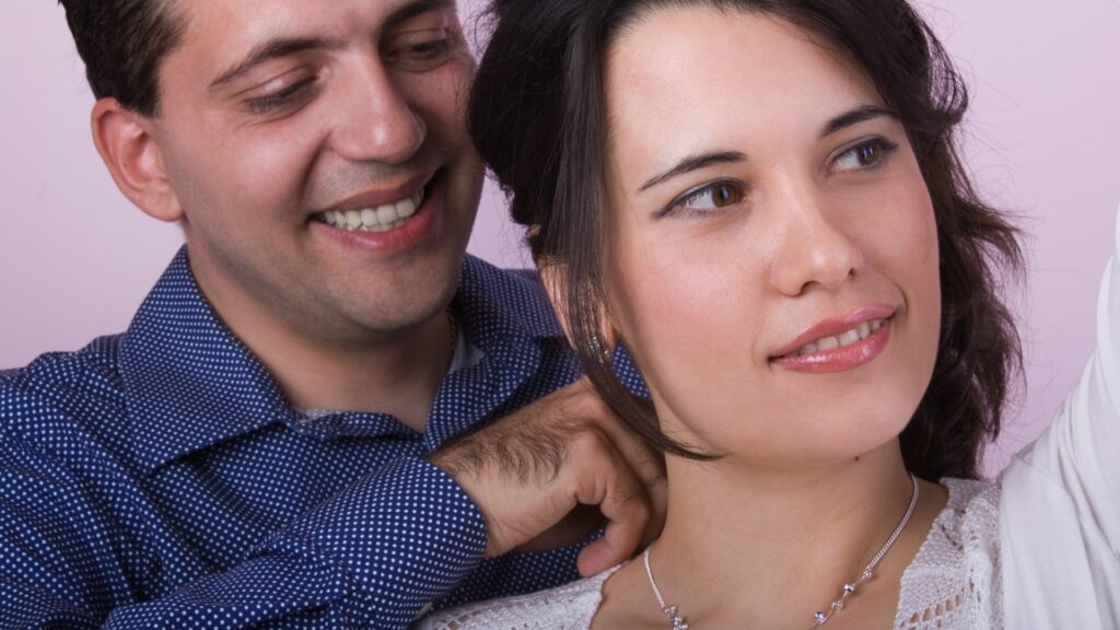 man helping lady to wear a personalized necklace 