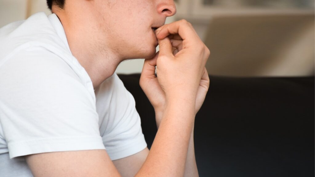 nervous young man biting his fingers
