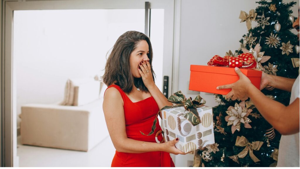 lady on red gown receiving a suprise gift from her long distance boy friend