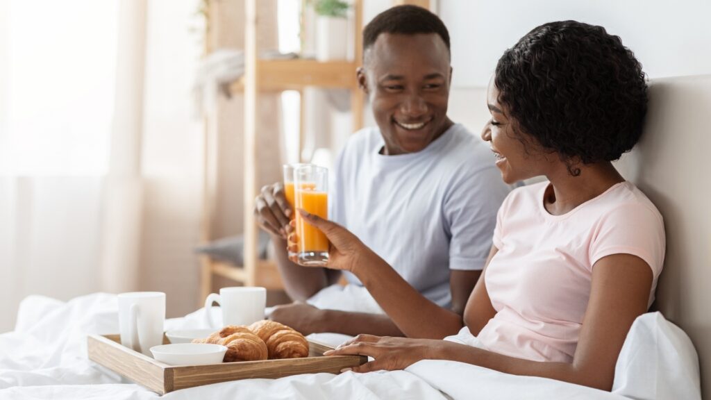 lady eating breakfast in bed as made possible by her long-distance boyfriend